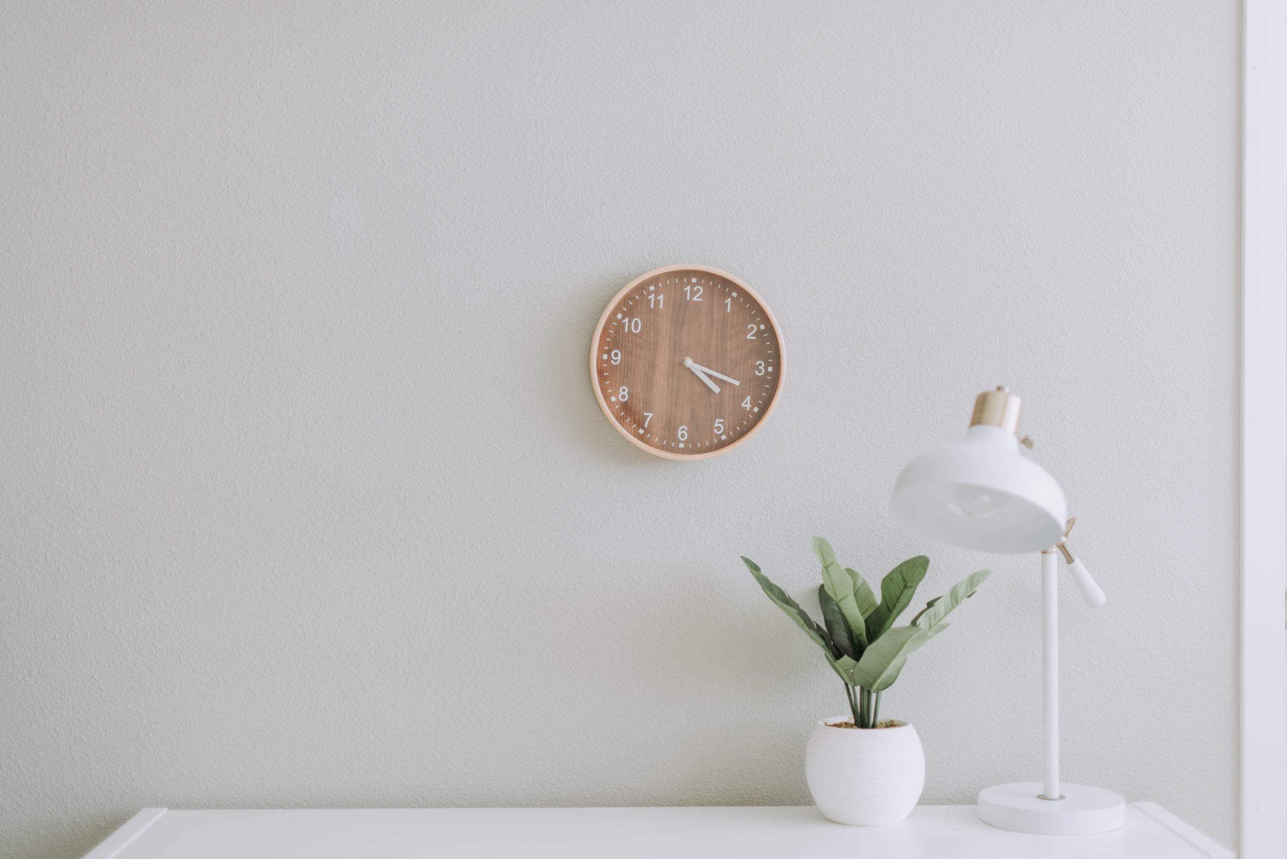 Espace de travail épuré, avec bureau, lampe et plante