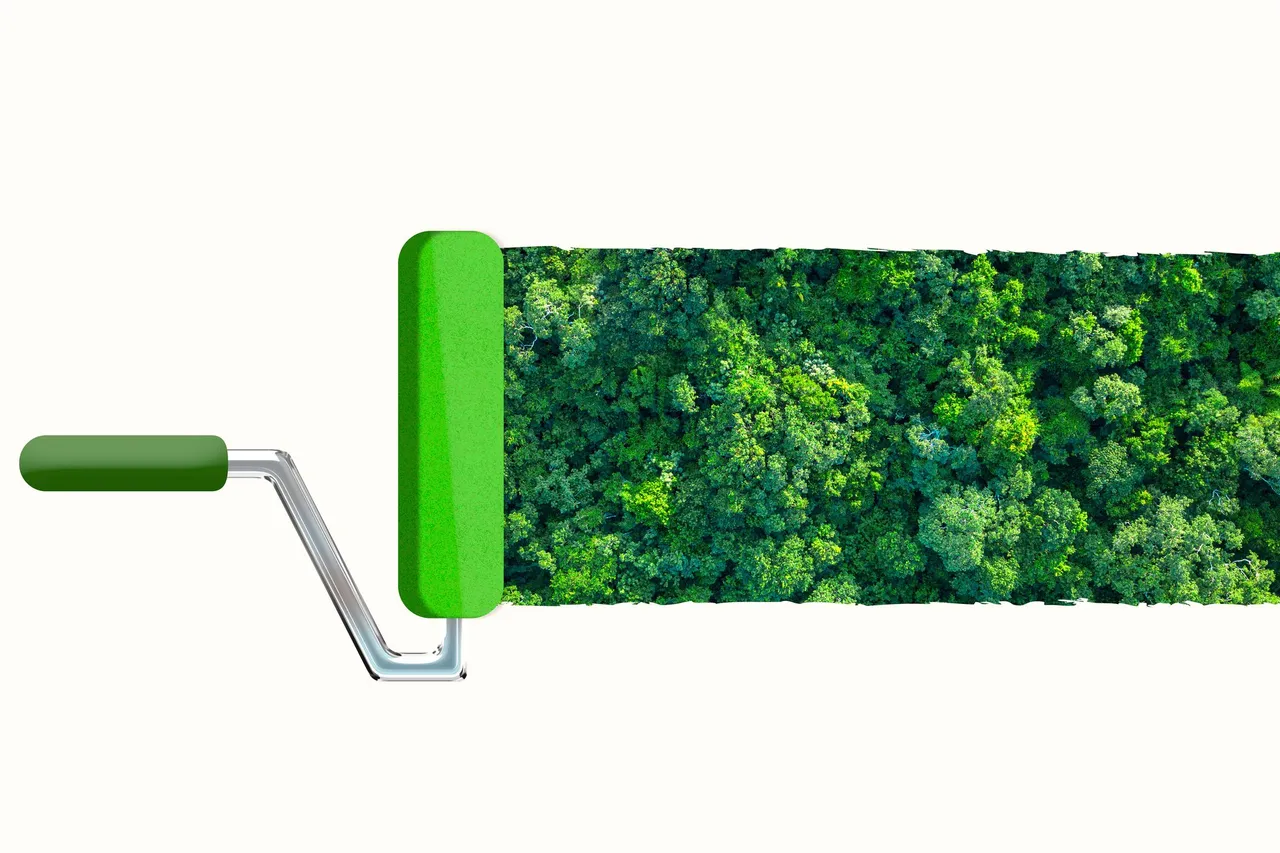 A green paint roller rolling out an aerial view of a dense forest