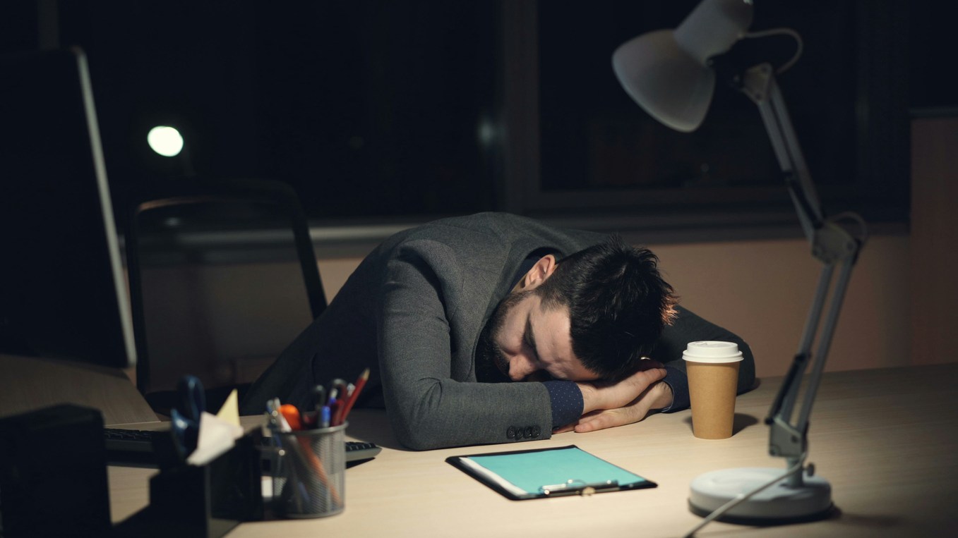 Jeune intermittent au travail - homme endormi sur son bureau