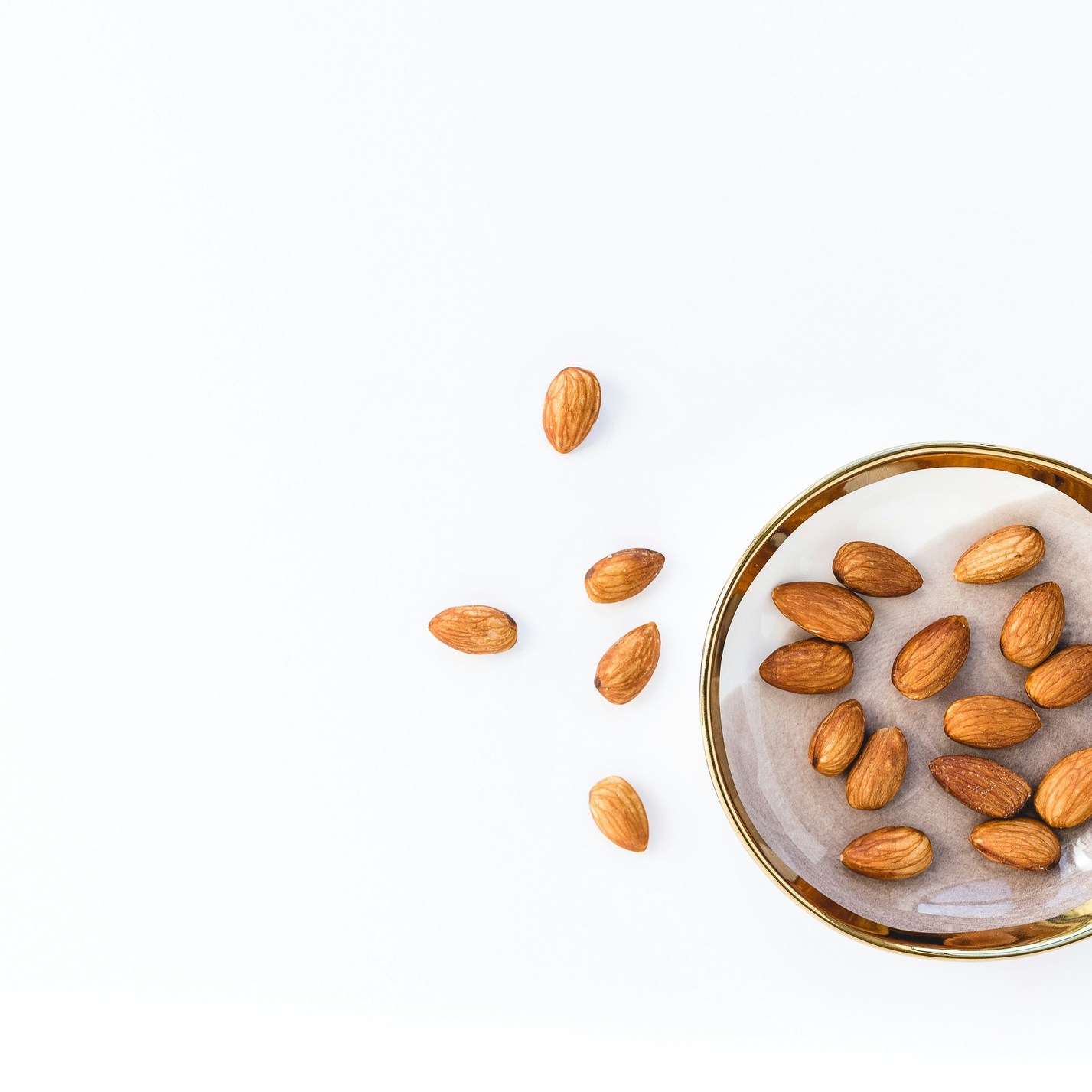 Bol d'amandes en vrac sur fond blanc
